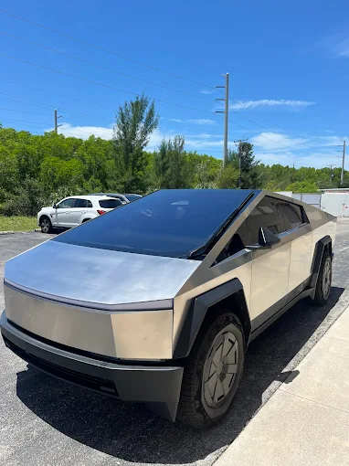Tamiami Tint of Naples installer carefully applying window tint film to a car window
