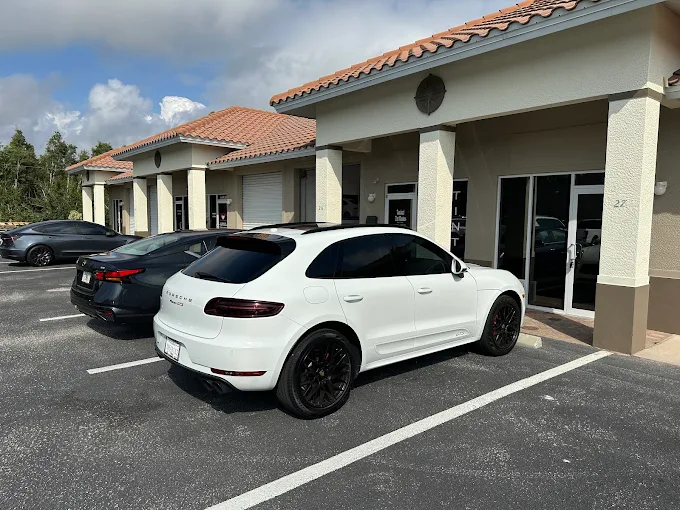 Tamiami Tint of Naples installer carefully applying window tint film to a car window